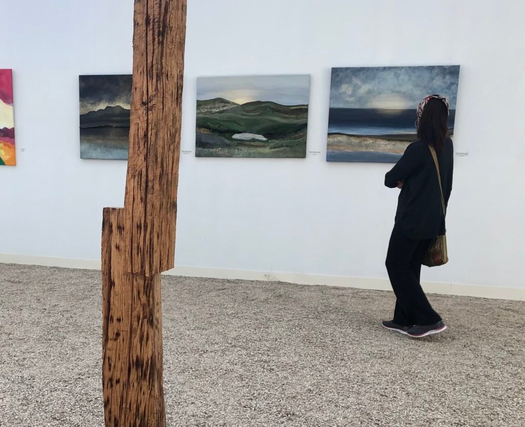 Une femme devant les tableaux d'A. Gosk-Zaleska au Salon des Beaux Arts 2022